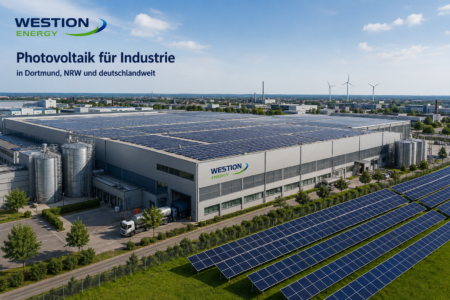 Industriegebäude mit großflächiger Photovoltaikanlage auf dem Hallendach und Freiflächen-Solaranlage